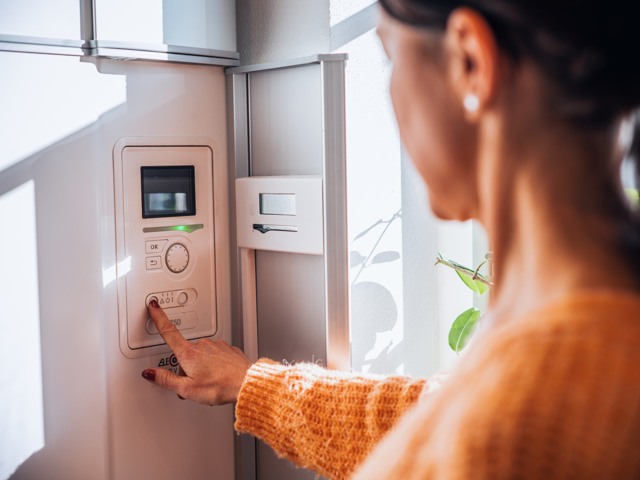 Kvinna som står vid värmepump