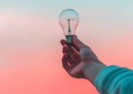 En hand som håller i en glödlampa