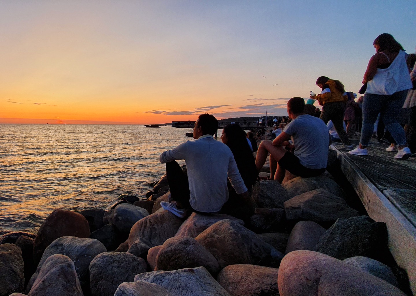 Personer på en brygga vid solnedgång