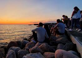 Personer på en brygga vid solnedgång