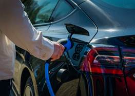 Person kopplar in laddare i elbil